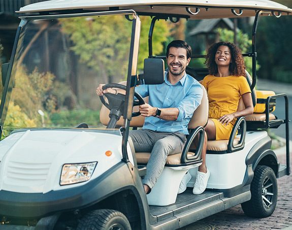 A couple driving a golf cart rental